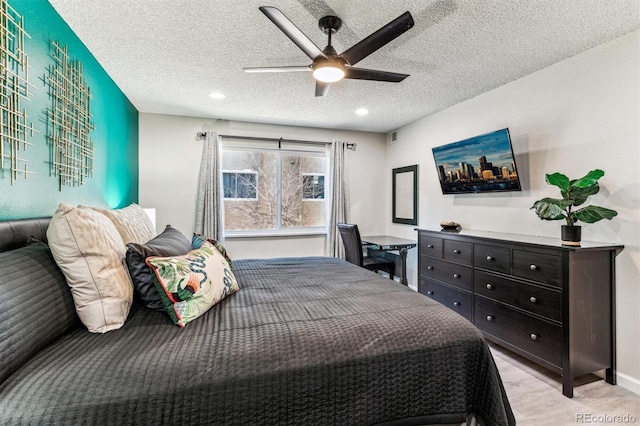 bedroom featuring a textured ceiling, visible vents, and a ceiling fan