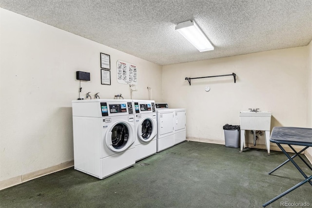 shared laundry area with washer and dryer, dark carpet, and a textured ceiling