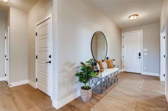 foyer entrance with light wood-style floors and baseboards