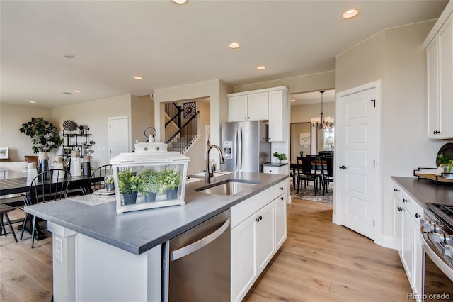 kitchen featuring appliances with stainless steel finishes, recessed lighting, a sink, and light wood-style floors