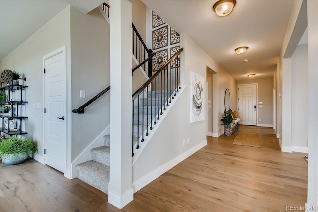 foyer featuring stairway, baseboards, and wood finished floors