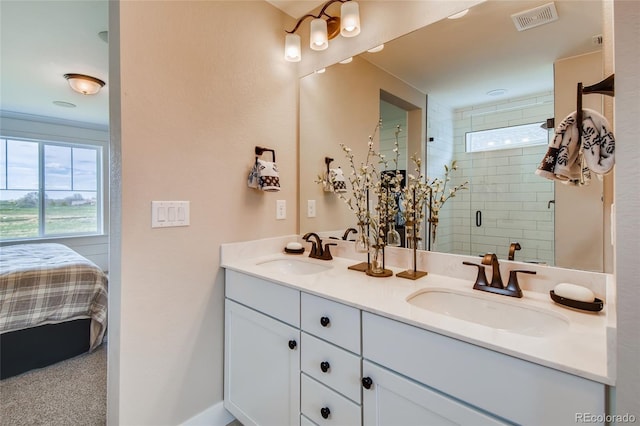 ensuite bathroom featuring double vanity, a stall shower, visible vents, and a sink