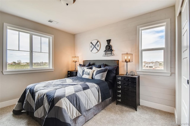 bedroom with visible vents, light carpet, baseboards, and multiple windows