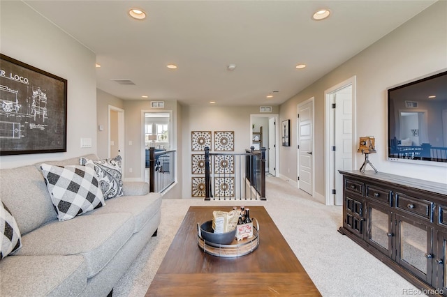 carpeted living area with baseboards, visible vents, and recessed lighting