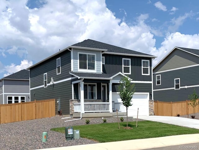 view of front facade featuring a porch, a front lawn, and a garage