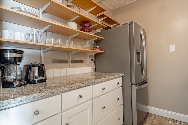 1255 N Ogden St Unit 305, Denver, CO 80218 - kitchen with stainless steel refrigerator with ice dispenser, white cabinets, light stone countertops, and light tile patterned floors