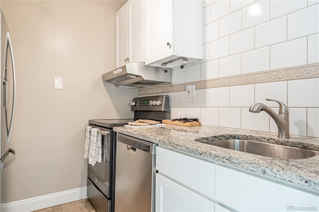 1255 N Ogden St Unit 305, Denver, CO 80218 - kitchen with stainless steel appliances, range hood, white cabinets, backsplash, and light stone countertops