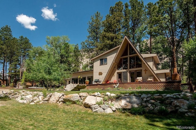 back of property featuring a deck, a yard, and french doors