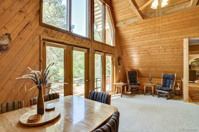 dining area featuring wooden walls, carpet flooring, wooden ceiling, and high vaulted ceiling