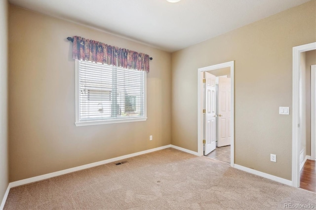 unfurnished bedroom with carpet, visible vents, and baseboards