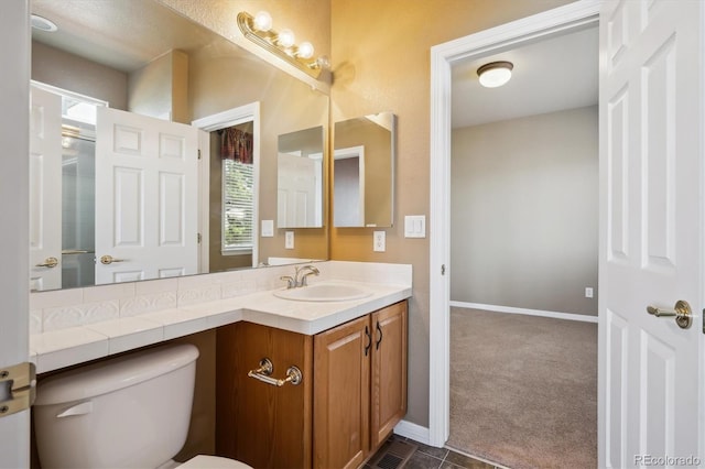bathroom featuring vanity, toilet, and baseboards