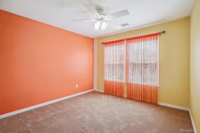spare room with ceiling fan, carpet, baseboards, and visible vents