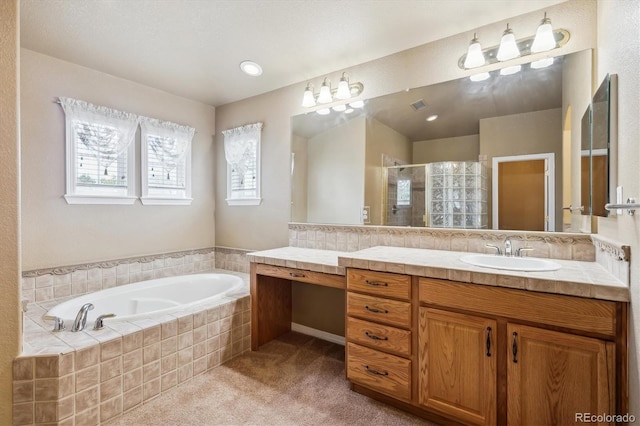 bathroom featuring a shower stall, a garden tub, vanity, and plenty of natural light