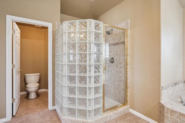 full bathroom featuring toilet, tile patterned floors, a stall shower, baseboards, and a bath