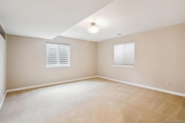 unfurnished room featuring carpet flooring, visible vents, and baseboards