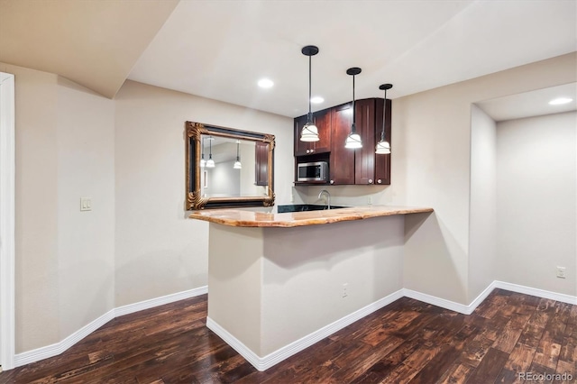 bar with stainless steel microwave, baseboards, and dark wood-style floors