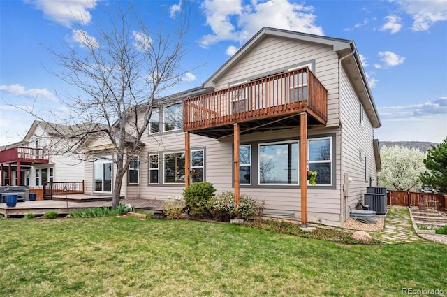 back of house featuring central AC unit, a wooden deck, fence, and a lawn