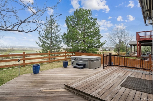 deck featuring a hot tub and a fenced backyard