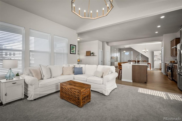 living area featuring dark wood-type flooring, vaulted ceiling, recessed lighting, and a chandelier