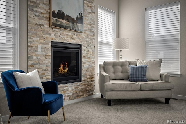 sitting room featuring carpet, a healthy amount of sunlight, baseboards, and a fireplace