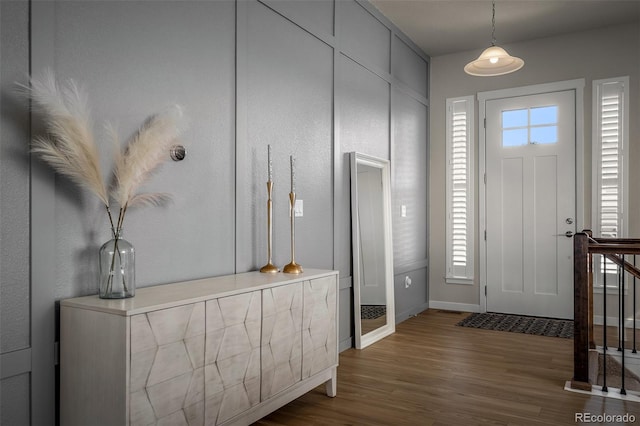 foyer entrance featuring dark wood-type flooring and baseboards