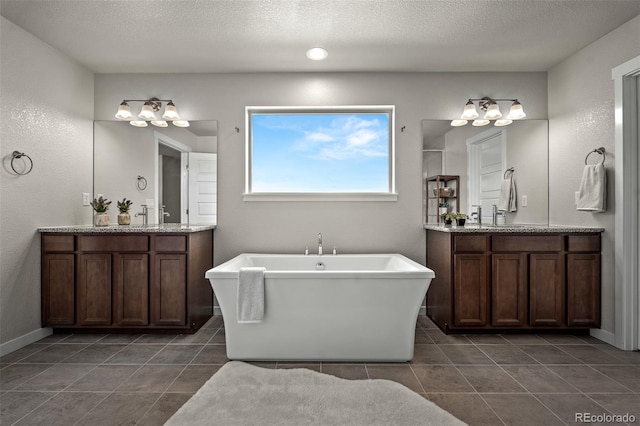 full bathroom featuring a soaking tub, a textured ceiling, and an inviting chandelier