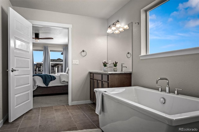 ensuite bathroom with a wealth of natural light, connected bathroom, vanity, and a ceiling fan