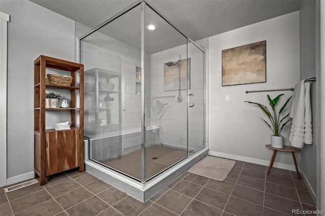 bathroom featuring tile patterned floors, visible vents, a stall shower, and baseboards