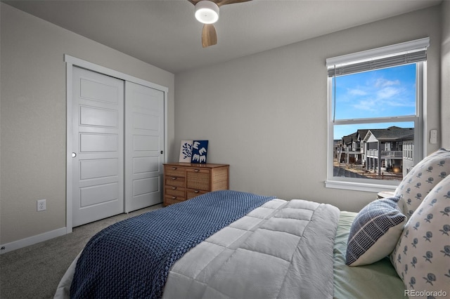 bedroom featuring a closet, baseboards, carpet, and a ceiling fan