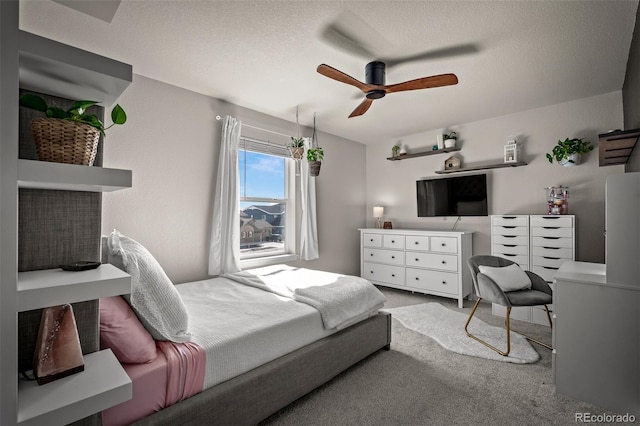 bedroom featuring a textured ceiling, ceiling fan, and carpet flooring