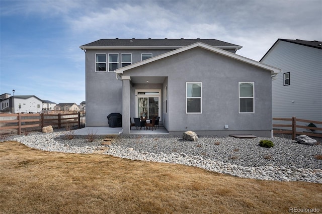 back of property featuring a patio, a yard, fence, and stucco siding