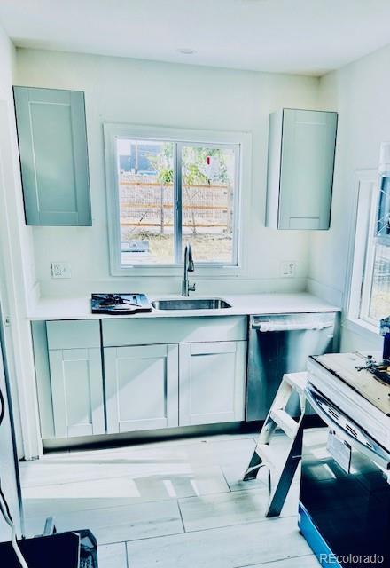 kitchen featuring white stove, light hardwood / wood-style floors, stainless steel dishwasher, and sink