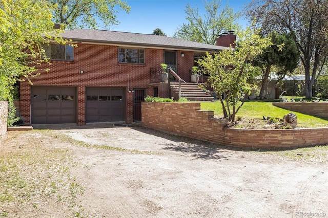 ranch-style house featuring a garage, a chimney, dirt driveway, brick siding, and a front yard