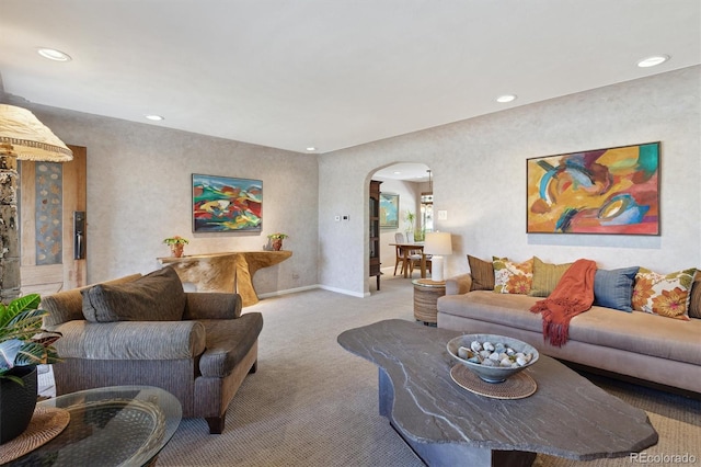carpeted living area with arched walkways, recessed lighting, and baseboards