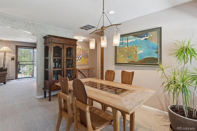 carpeted dining room with baseboards, arched walkways, and recessed lighting