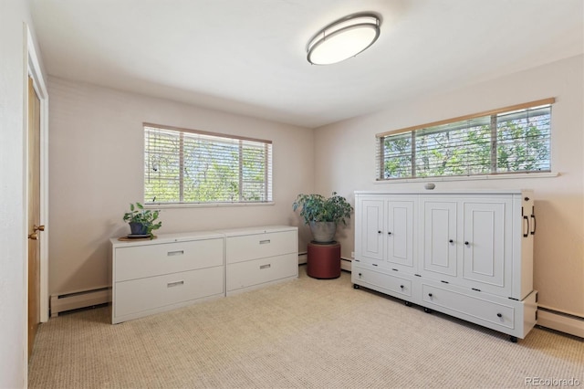 bedroom with baseboard heating, multiple windows, and light carpet