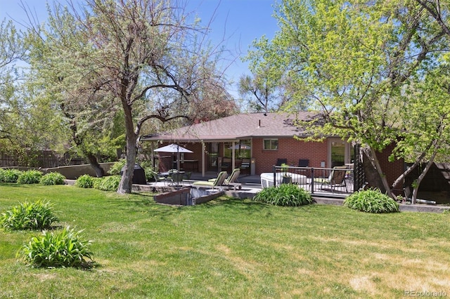 rear view of property with brick siding and a patio