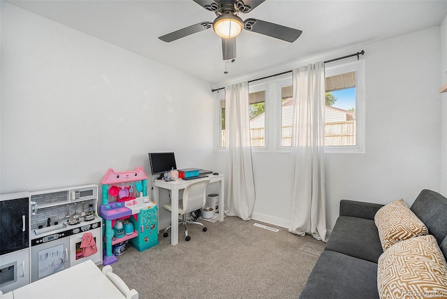 carpeted office featuring ceiling fan