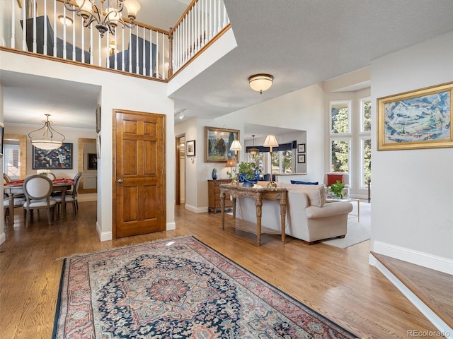 entryway featuring a towering ceiling, baseboards, and wood finished floors