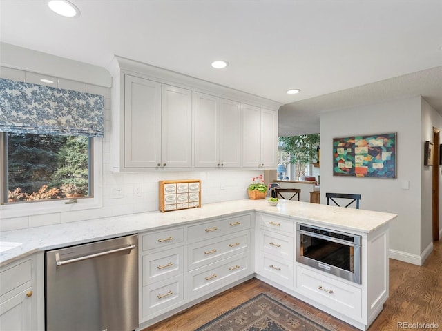 kitchen featuring backsplash, white cabinetry, dark wood-type flooring, and dishwasher