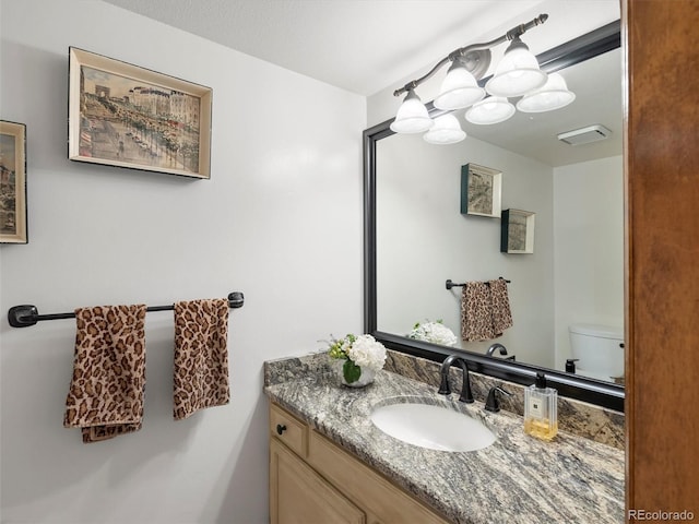 bathroom featuring visible vents, vanity, and toilet