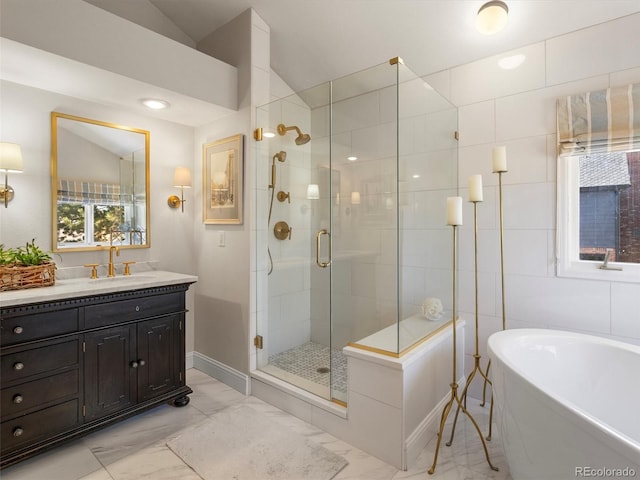 bathroom with marble finish floor, a soaking tub, a stall shower, vaulted ceiling, and vanity