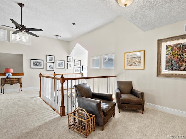 sitting room featuring light carpet, baseboards, vaulted ceiling, and a textured ceiling