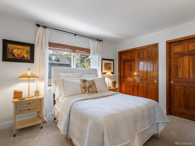 bedroom with baseboards and light colored carpet