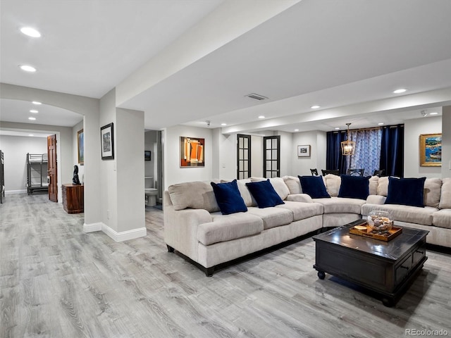 living room with baseboards, light wood-style flooring, visible vents, and recessed lighting