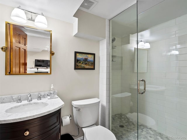 bathroom featuring toilet, a shower stall, visible vents, and vanity