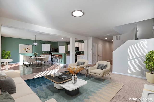 living room with carpet and a notable chandelier