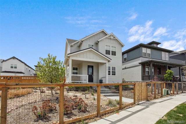 view of front of property featuring a fenced front yard, board and batten siding, and covered porch
