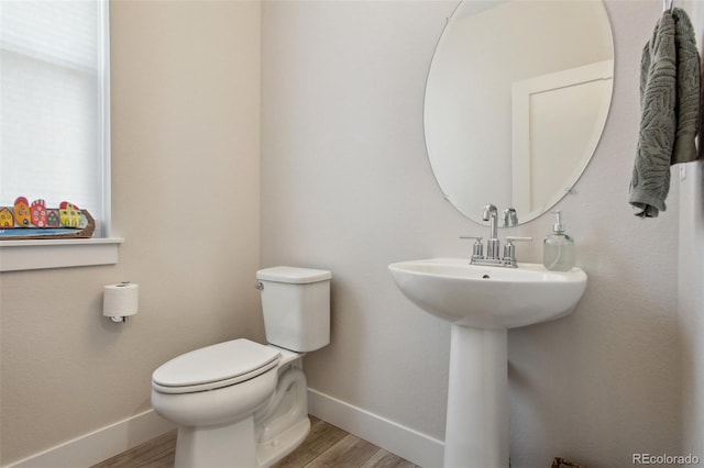 bathroom with baseboards, toilet, and wood finished floors
