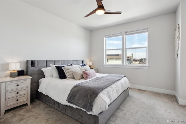 bedroom with a ceiling fan, baseboards, and light carpet